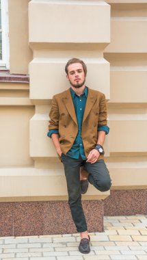 Bir duvara yakın duran genç bir adam