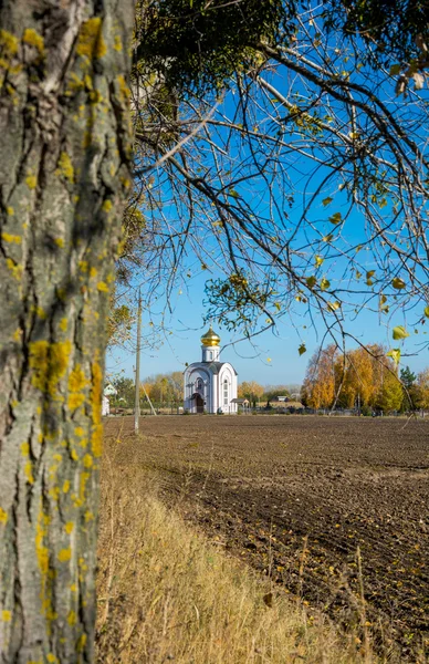 Kerk aan de rand van geploegd veld. — Stockfoto
