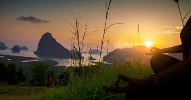 Yogada tek başına oturan, rahatlayan ve meditasyon yapan, ruhsal ve zihinsel sağlık konsepti olan kadın silueti..