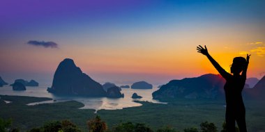 Siluet gezgini kadın kollarını kaldırmış dağ manzarası Khao Sok Ulusal Parkı 'nın tepesinde dinleniyor ünlü eğlence yeri Tayland seyahati.
