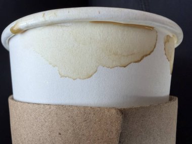 Kahverengi lekeli ve karton kollu kağıttan bir kahve bardağının yakın çekimi. Kafein alışkanlığı, içecek servisi.