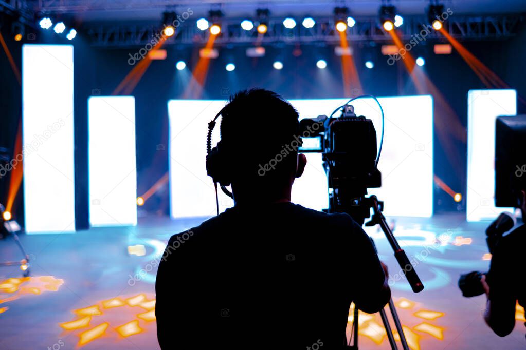 Professional cameraman - covering on event with a video, cameraman silhouette on live studio news, Selective focus