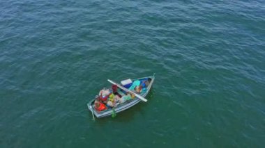 Hava manzaralı, balıkçı teknesi ve kıyıya yakın balıkçılar.