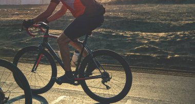 Gün batımı otoyolunda bisiklet süren bir grup bisikletçi arkadaş, gün batımı bisiklet yarışması