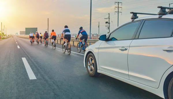Otobanda güvenlik eskortu arabasıyla bir grup profesyonel bisikletçi eğitimi alıyor. Bir grup bisikletçi tarafından takip edilen ekip arabaları.