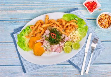 Peru yemekleri: balık ceviche ve chicharron de pescado kızarmış kasava, tatlı mısır ve tatlı patates, beyaz tabakta servis edilen geleneksel Peru ceviche, yanında balık, mısır pankeki, tatlı patates, canchita ve bol baharatlı meyve suyu. Ceviche 