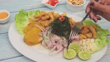 Peru yemeği: balık ceviche ve chicharron de pescado kızarmış kasava, tatlı mısır ve tatlı patates, beyaz bir tabakta servis edilir.