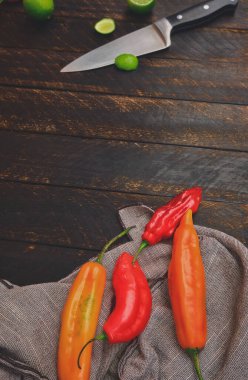 Ahşap masa ve bıçak (limuzin biberi, karabiber ve limon) üzerinde diğer malzemeler içeren Peru biberleri) üst görünüm. Seçici odak