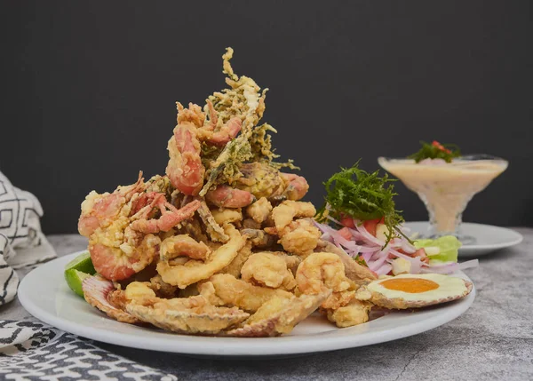 Peru yemeği: chicharron de pescado ya da kızarmış kasava ile balık çıtırtısı ve kırmızı biberli soğan salatası, beyaz tabakta servis edilir. Seçici odak