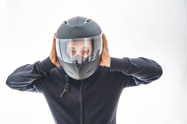 Motosiklet kasklı bir adam iyi niyet gösterisi yapıyor. Beyaz stüdyo duvarında izole edilmiş..