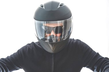 Siyah kareli ceketli ve motosiklet kasklı bir adamın portresi. Motosiklet sürüyormuş gibi yapıyor..