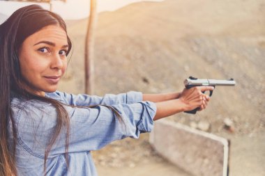 Kadının stres atması, eğitmenin silahlı kadına yardım etmesi.