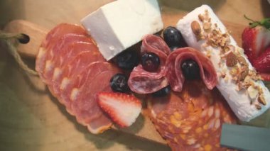 Peynirli salam ve meyveli Charcuterie tahtasının en üst görüntüsü.