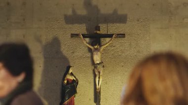 Kilise cemaati, katolik bir katedralin içindeki haçın önünde dini bir ayine katılıyor.
