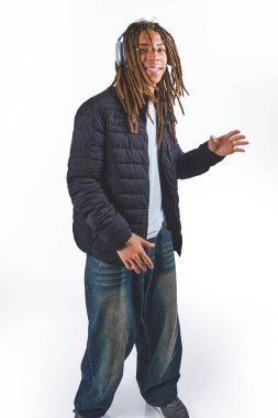 Rastalı siyah adam kulaklıkla müzik dinliyor.