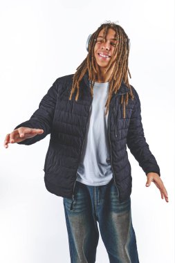 Rasta ve kulaklık takan genç siyahi bir adam beyaz bir arkaplanda poz veriyor.