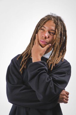 Beyaz arka planda rastalı genç bir adam, düşünceli bir şekilde