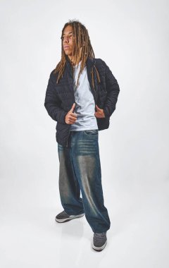 Rastalı genç adam çağdaş şehir modası giyiyor.