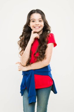 Uzun kıvırcık saçlı mutlu kız. çocukluk mutluluğu. Kuaför salonu. Cilt bakımı ve doğal saç. moda ve güzellik. hippi çocuk. Küçük kız gülümsüyor. Uzun kıvırcık saçlar mükemmel görünüyor. Esmer saçlı.