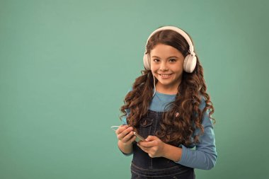 Modern aletler. Müzik konseptinin tadını çıkar Müzik uygulaması. Ses kitabı. Eğitici içerik. Dil derslerine çalış. Kız müzik dinler modern kulaklıklar ve akıllı telefonlar. Bedavaya dinle. Müzik aboneliği