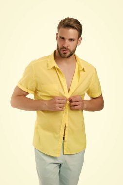 Yakışıklı maço manken. Seksi maço alışveriş kıyafetleri. Sıcak bir gün. Sıcaklık mevsimi. Modern moda. Soyunma odası. Çekici bir adamın gömleğini çıkarması. Cazibesine güveniyor. Sakallı adam gündelik tarzda