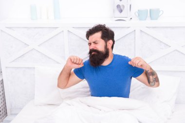 Sabah uykusu. Barışçıl yetişkin erkek dinleniyor. Sakallı adam yatakta geriniyor. Uykulu adam yatak odasında rahatla. Sabah erkenden. Vücudunun ihtiyacı olan dinlenme için. Yatak çok rahat.