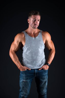 Güçlü ol. Sıradan tarzda siyah arka planda güçlü bir adam. Pazı ve kol kasları yapıyorlar. Kas egzersizi. Spor ve spor. Vücut bakımı ve sağlık. Sağlık ve diyet. Güçlü ol.