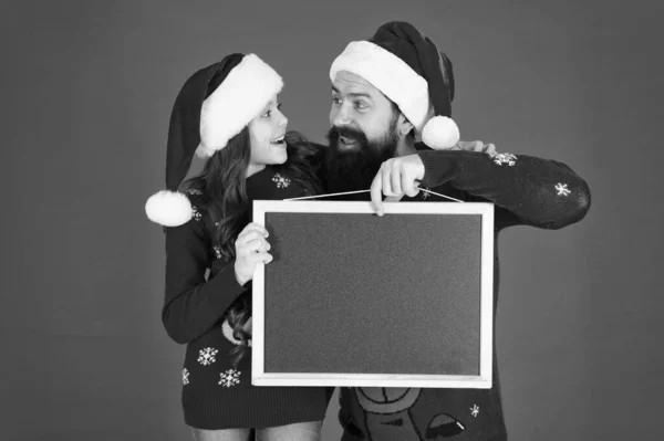 新年とクリスマスパーティーの広告。幸せな家族は広告板を保持する。髭の男と小さな子供の広告製品やイベント。あなたの休日の広告はここ、スペースをコピー — ストック写真