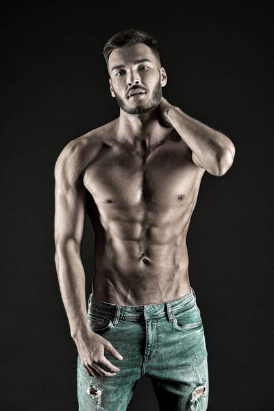 Зацени мою форму. Мужчина мускулистый туловище напряженные мышцы вены джинсовые брюки. Мачо мускулистая грудь выглядит привлекательным черным фоном. Спортсмен с мускулистым телом на уверенном лице гордится своей формой