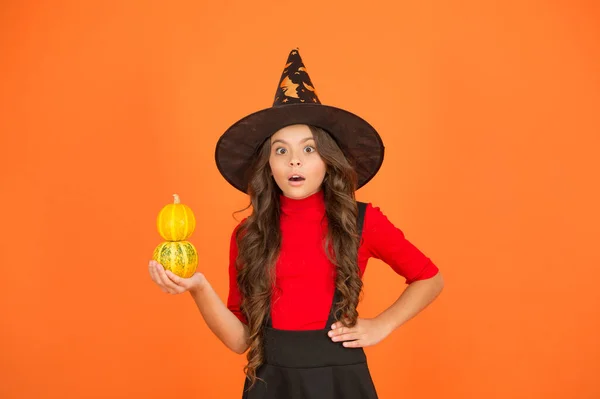 Menina surpreso em traje de chapéu de bruxa para halloween com pequena abóbora amarela, festa feliz halloween — Fotografia de Stock