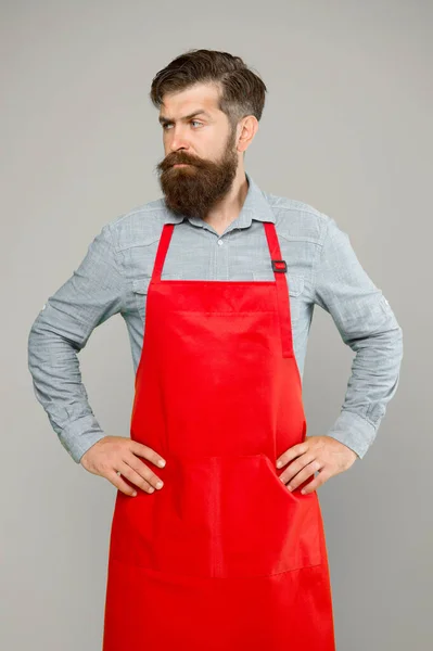 Cooking at home. Helping around house. Bearded man in cook uniform. Mature shop assistant. Chef in red apron. Restaurant staff. Cooking hobby. Lots of delivery day options. Whole family would enjoy — Stock Photo, Image