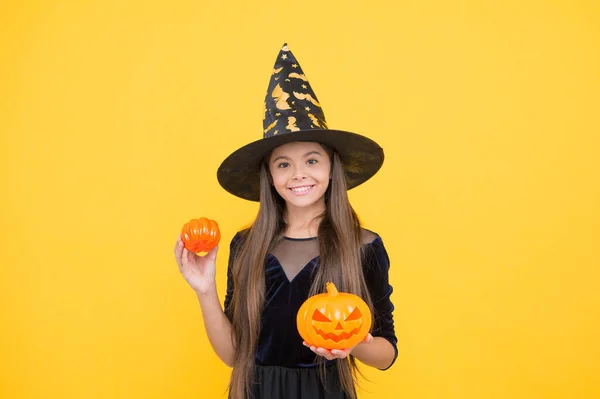 Happy child wear witch hat holding pumpkin to create jack o lantern on halloween, happy halloween tradition — Stock Photo, Image