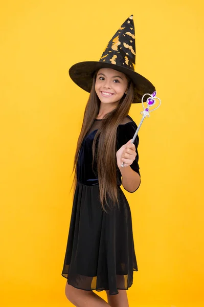 Felice bambino indossare cappello strega tenendo bacchetta magica per creare incanto su Halloween, magia di Halloween — Foto Stock