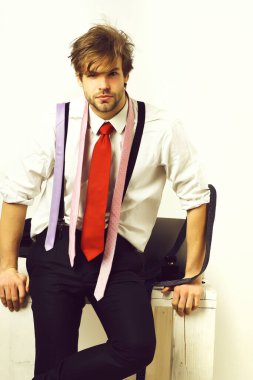 Beyaz arka planda renkli kravatları olan sakallı maço adam.