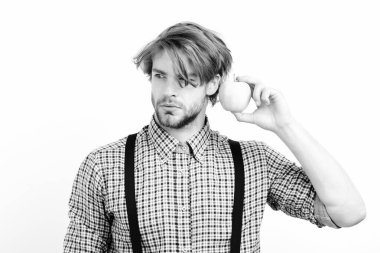 Sakallı ve şık saçlı adam yeşil elma tutuyor.