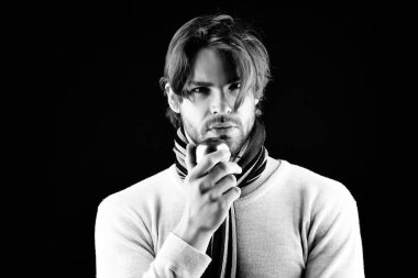 Sakallı ve özenli bakışlı adam altın elmayı tutuyor.