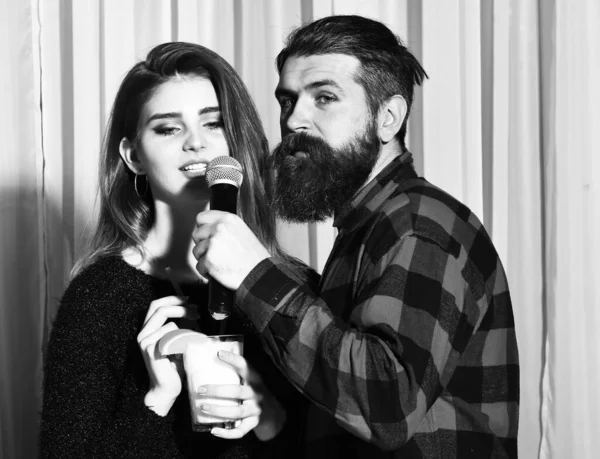 Mooi meisje en bebaarde man met baard in karaoke bar — Stockfoto