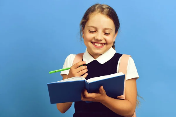 Regreso al concepto de escuela y educación. Chica sostiene libro azul —  Fotos de Stock