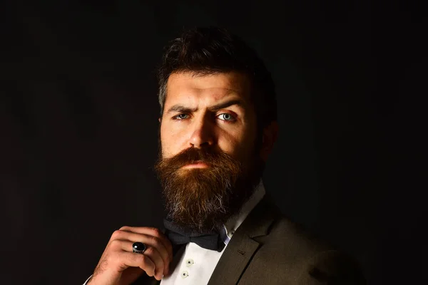 Businessman with confident face adjusts bow tie