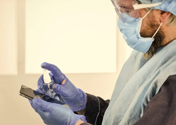 man in sanitary doctor uniform. man wear respirator mask, gloves and protective glasses. stay safe at home. coronavirus pandemic outbreak. hygiene on lock down. remote work concept