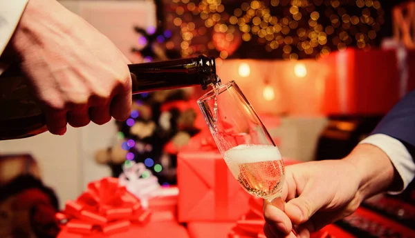 Beba champanhe ou vinho espumante. Celebre o Ano Novo com o champanhe. Mãos derramando champanhe em vidro elegante fundo decorações de Natal. Um conceito de saúde. Último minuto antes do ano novo — Fotografia de Stock