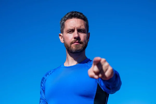 Sebevědomý sportovec ve sportovním oblečení ukazující prstem na pozadí oblohy, fitness trenér — Stock fotografie