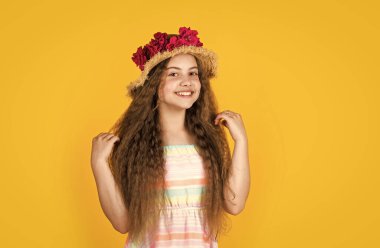 Şapkalı küçük bir kız. Yaz tatili ve tatil. Kadın güzelliği ve moda. çocukluk mutluluğu. Kafasında çiçek dekoru olan mutlu bir çocuk. Bahar şapkalı çocuk.