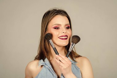 Moda makyaj suratı. Profesyonel makyaj fırçası olan seksi bir kadın. Uzun saçlı, tarz sahibi şehvetli bir kadın. Güzellik kuaförü salonu. Ruj ve göz farı. Cinsellik. Cilt kozmetiği. Cilveleşiyorum.