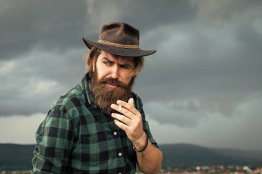 Kötü alışkanlık. Teksas vahşi kovboyu. Bıyıklı vahşi hippi şapkalı. Manken gündelik batı kıyafetleri giyer. Erkek güzellik standardı. Çok modaya uygun görünüyorsun. Kendine güvenen ve yakışıklı bir adam. Sakallı adam