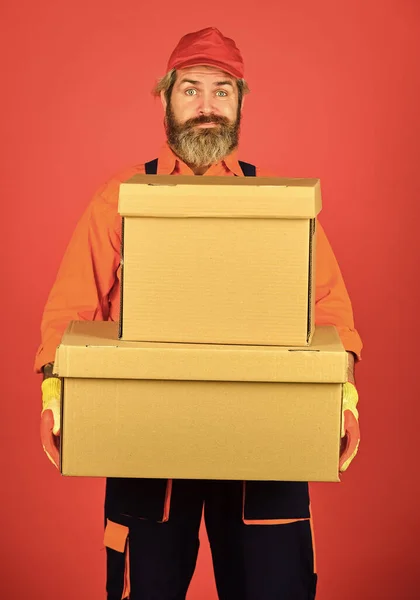 Man builder in boilersuit hold boxes. Umzug in eine neue Wohnung. Glücklicher Mann Karton. Kisten im Gebäude tragen. Umzugskartons auspacken. Neues Haus am Umzugstag. Liebe, wo du wohnst — Stockfoto