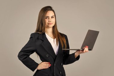 İnternette tasarım ilhamı arıyorum. Şık bir kadın dizüstü bilgisayarını tutuyor. Dizüstü bilgisayarı olan kendine güvenen bir iş kadını. Ceketli, zarif, gülümseyen kadın. İnternet ofis çalışanı. resmi gündelik moda tarzı