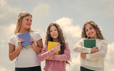 Bilgiye doğru. Okul öğrencileri edebiyat öğreniyor. Çocuklar kitap okuyor. Deftere yazan üç kız. Okula dönüyorum. Anıları günlüğe yaz. Eğitim ve okul kavramı