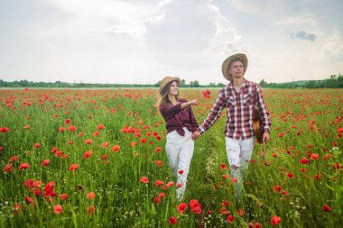 Haşhaş tarlasında el ele tutuşan genç bir çift, aile değerleri