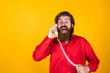 Haberler çok iyi. Sakallı ve bıyıklı adam çağrıya cevap veriyor. Telefon görüşmesi. Sakallı adam. Modern hayatta iletişim. Telefonda arkadaşınla konuş. Olgun erkek retro telefonu tut